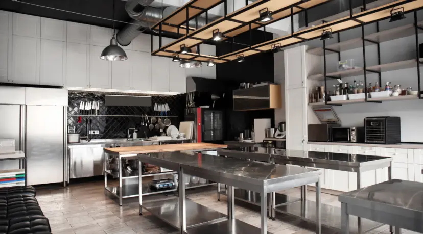 A kitchen with stainless steel counters and tables.