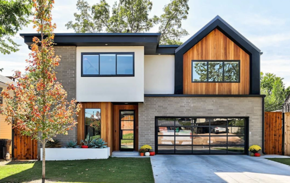 A modern home with wood paneling and black windows.